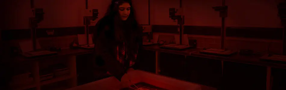 students developing photographs in dark room